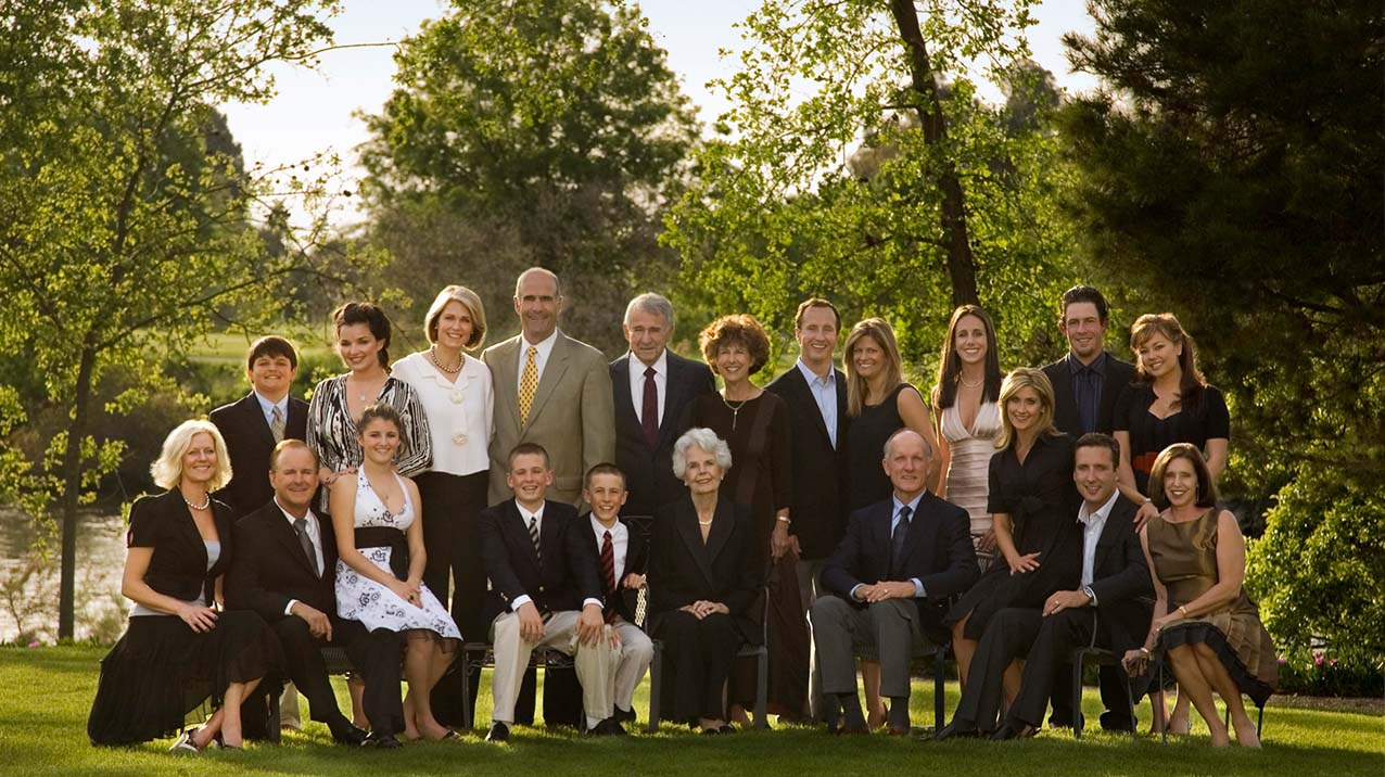 The entire Klein family poses together on a green lawn with lush green trees in the background