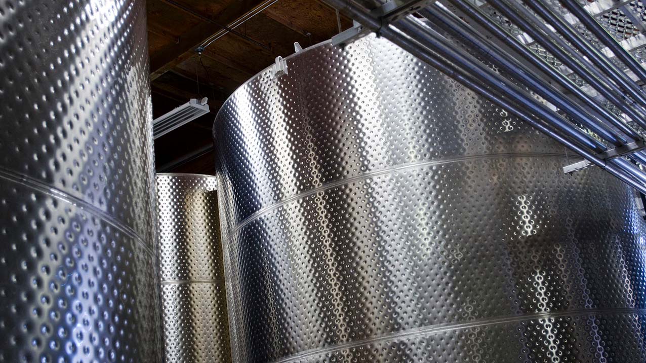 Tall, round stainless steel fermentation tanks in the cellar at Rodney Strong Vineyards