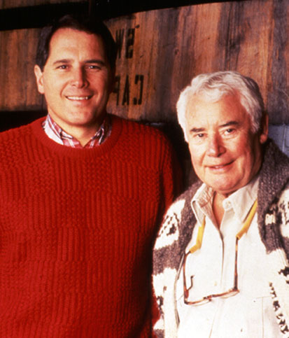 Winemaking Emeritus Rick Sayre and Rod Strong smile in front of a tall wine cask