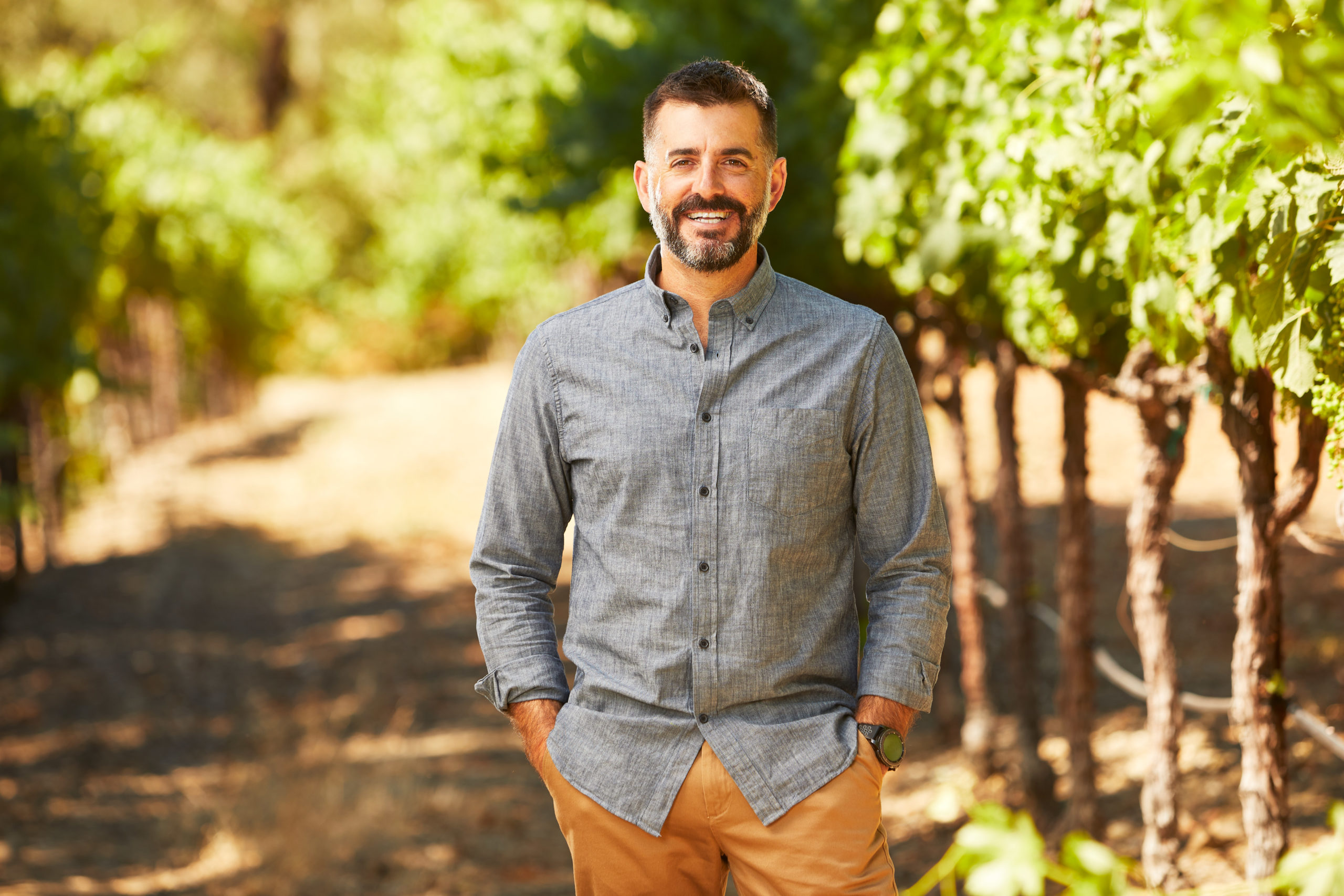 Man standing in vineyard smiling