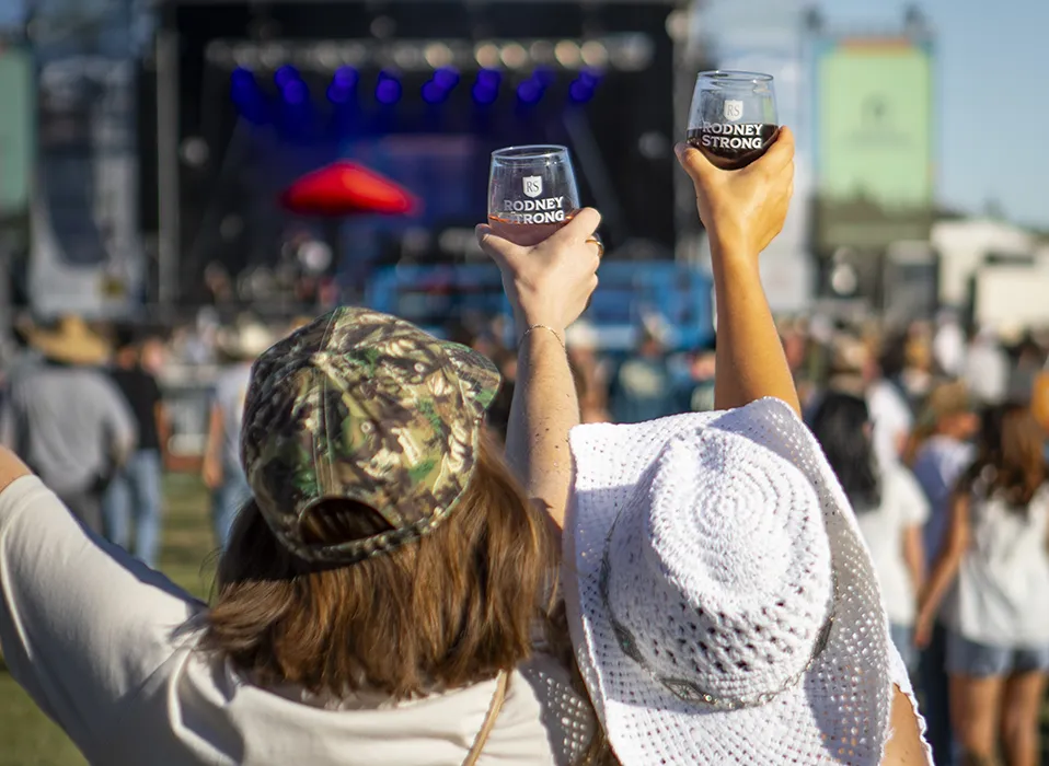 Two women watching artists on stage at Country Music Festival